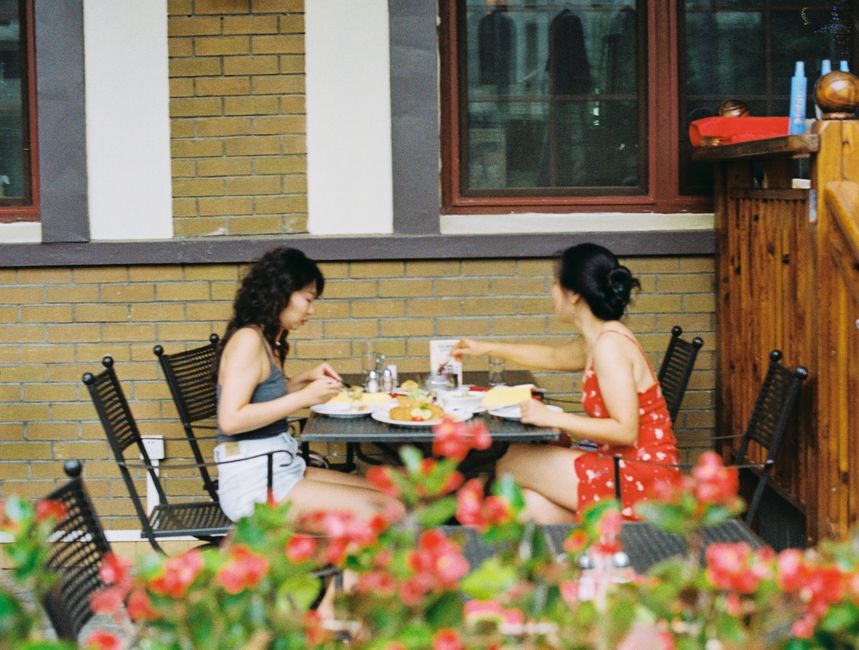 Two diners enjoying fresh food outdoors at a restaurant patio