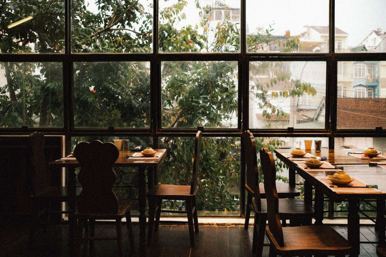 Restaurant dining room with large windows overlooking a city street